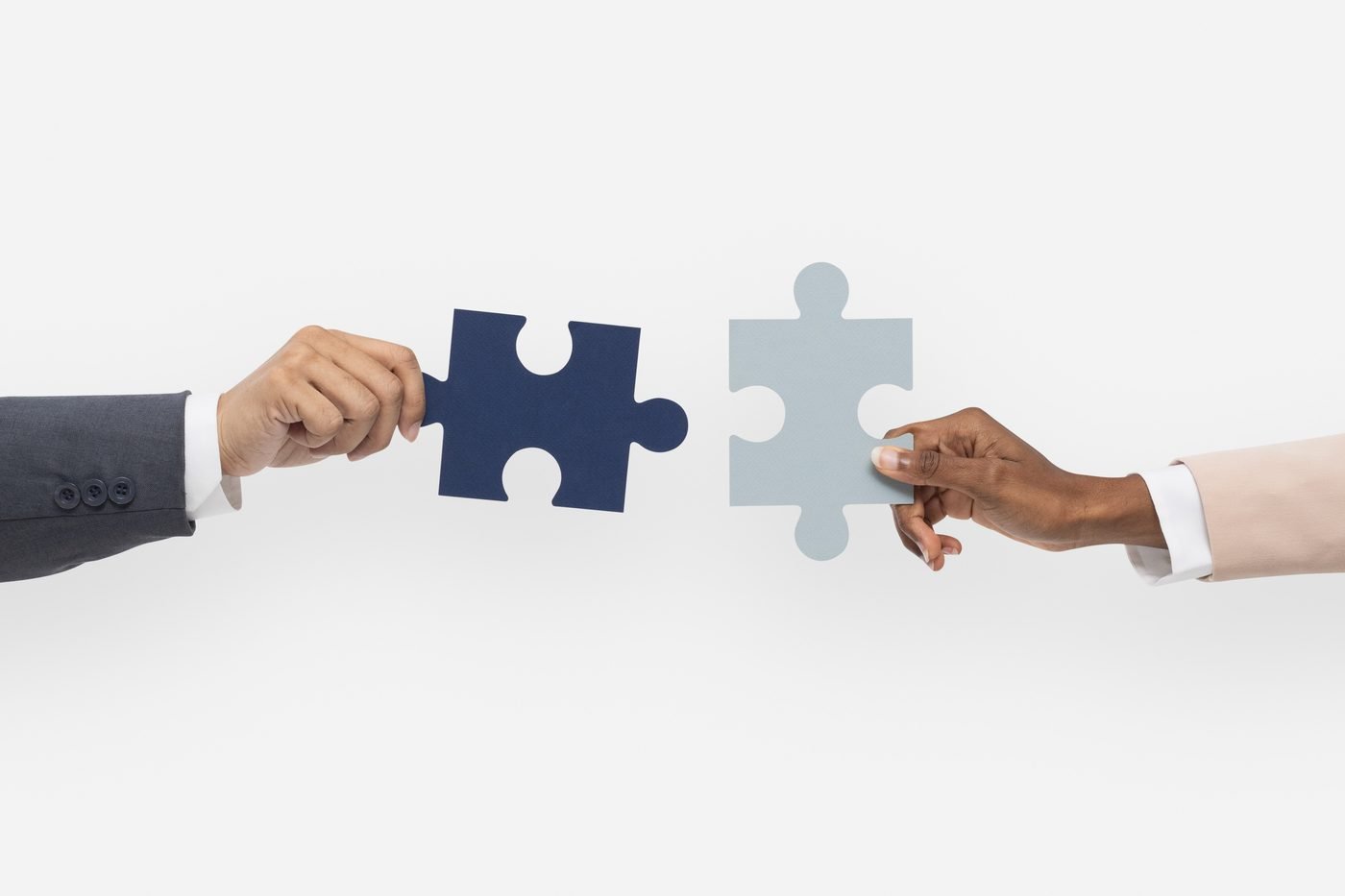 Two hands fitting jigsaw pieces together
